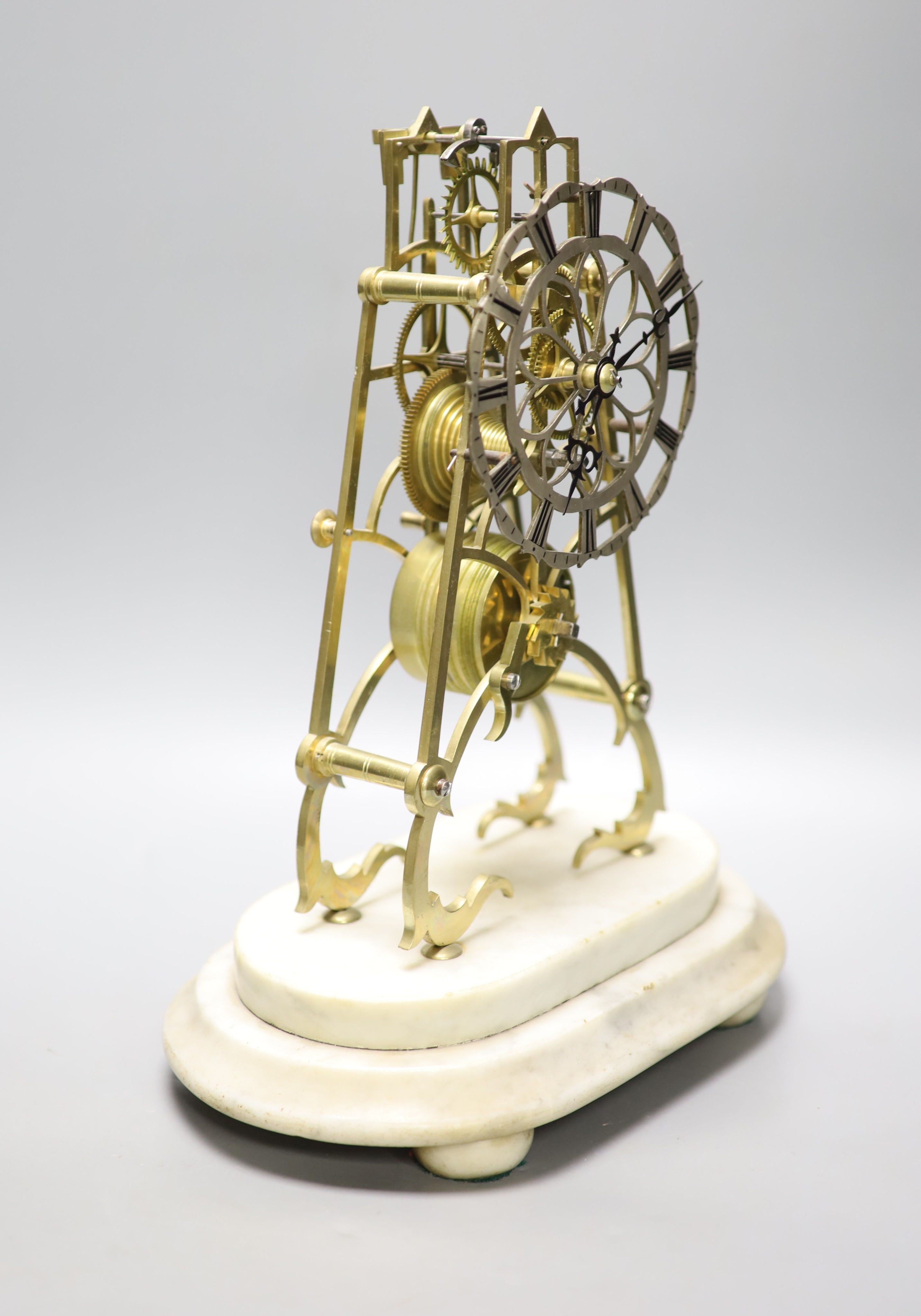 A 19th century brass skeleton clock on marble base. Associated glass dome, total height 44.5 cm